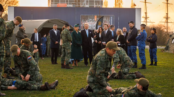 Het Koninklijk paar kijkt naar militairen die oefenen met het verzorgen van gewonden. 