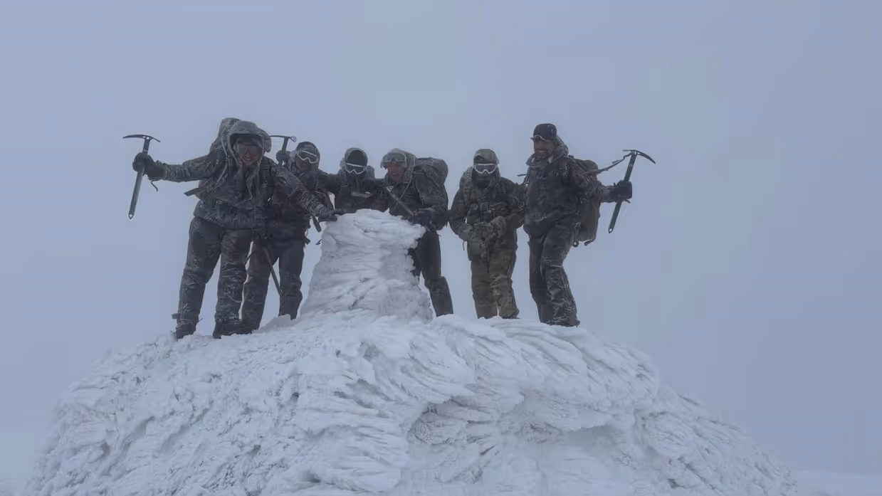 De mariniers staan op de top van de berg. 