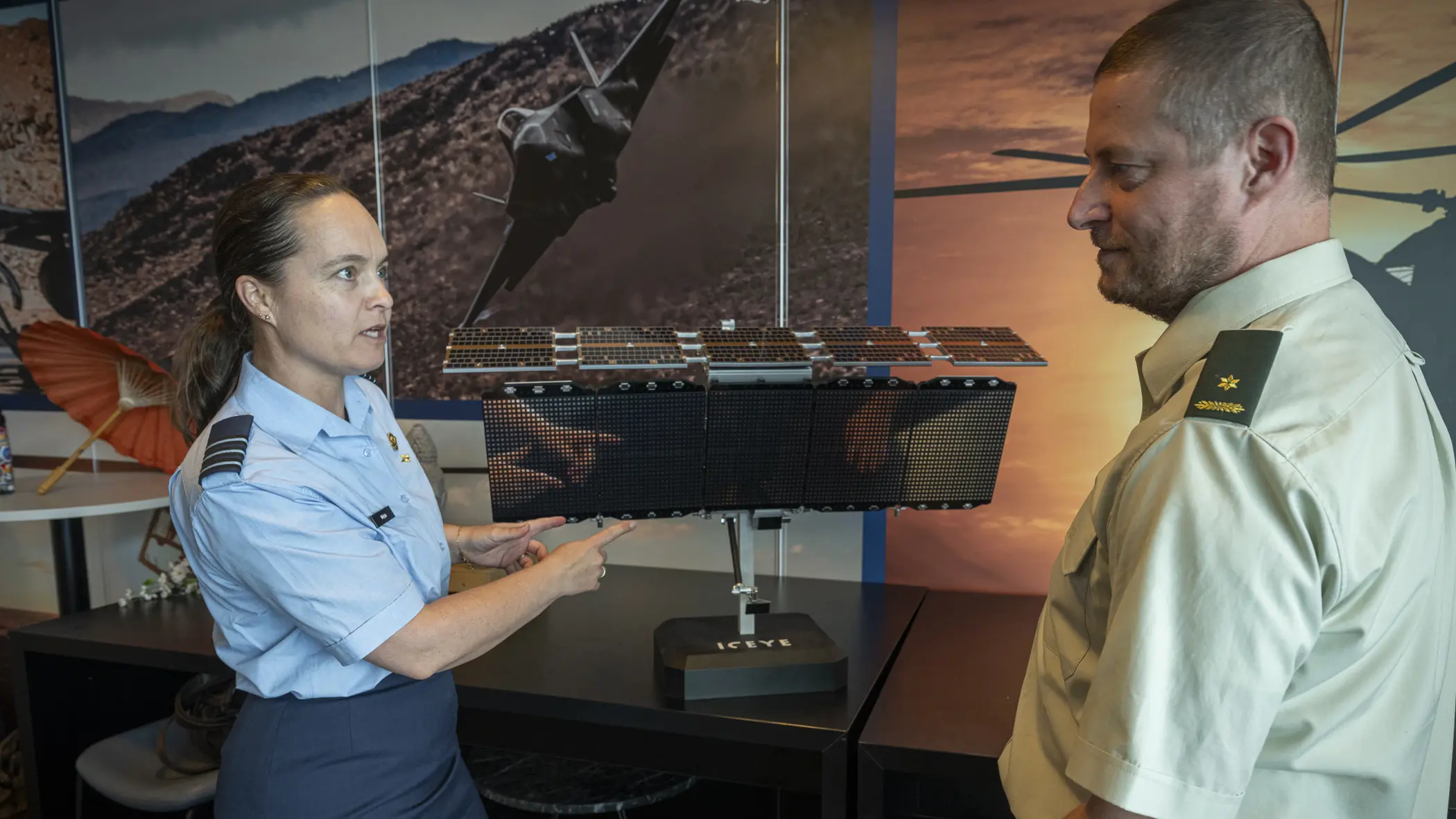 Luitenant-kolonel Petra Wijnja en majoor Edwin Winters bij een model van de ICEYE satelliet