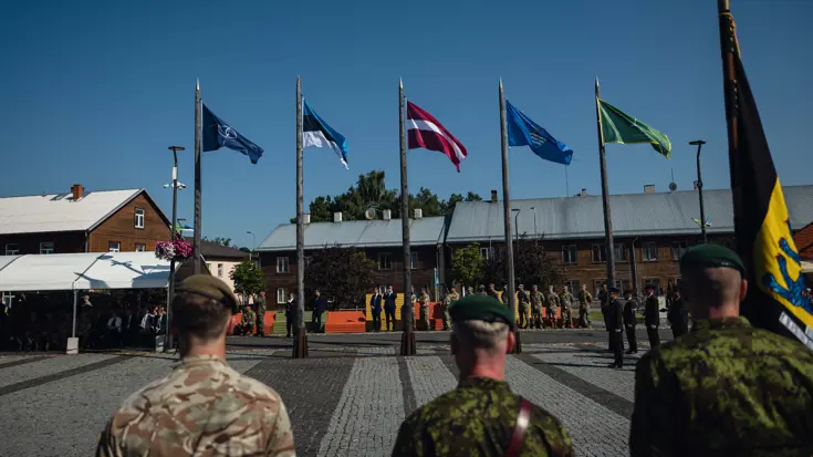 Militairen en vlaggen op een paradeplaats tijdens een overdracht.