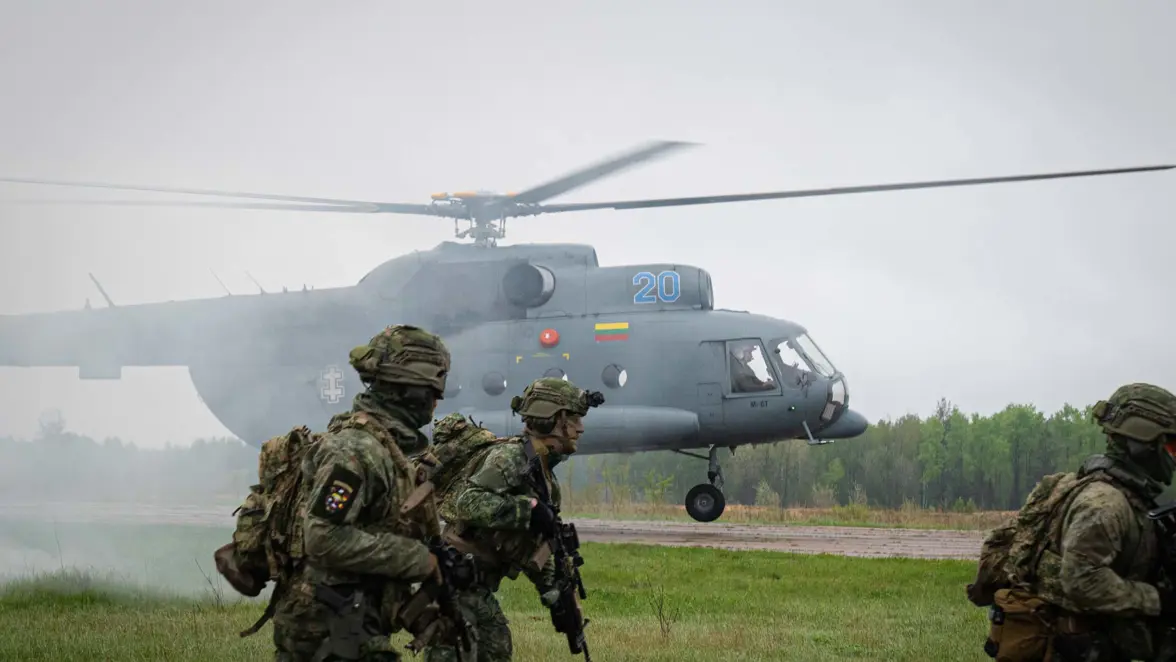 Militairen met op de achtergrond een heli.