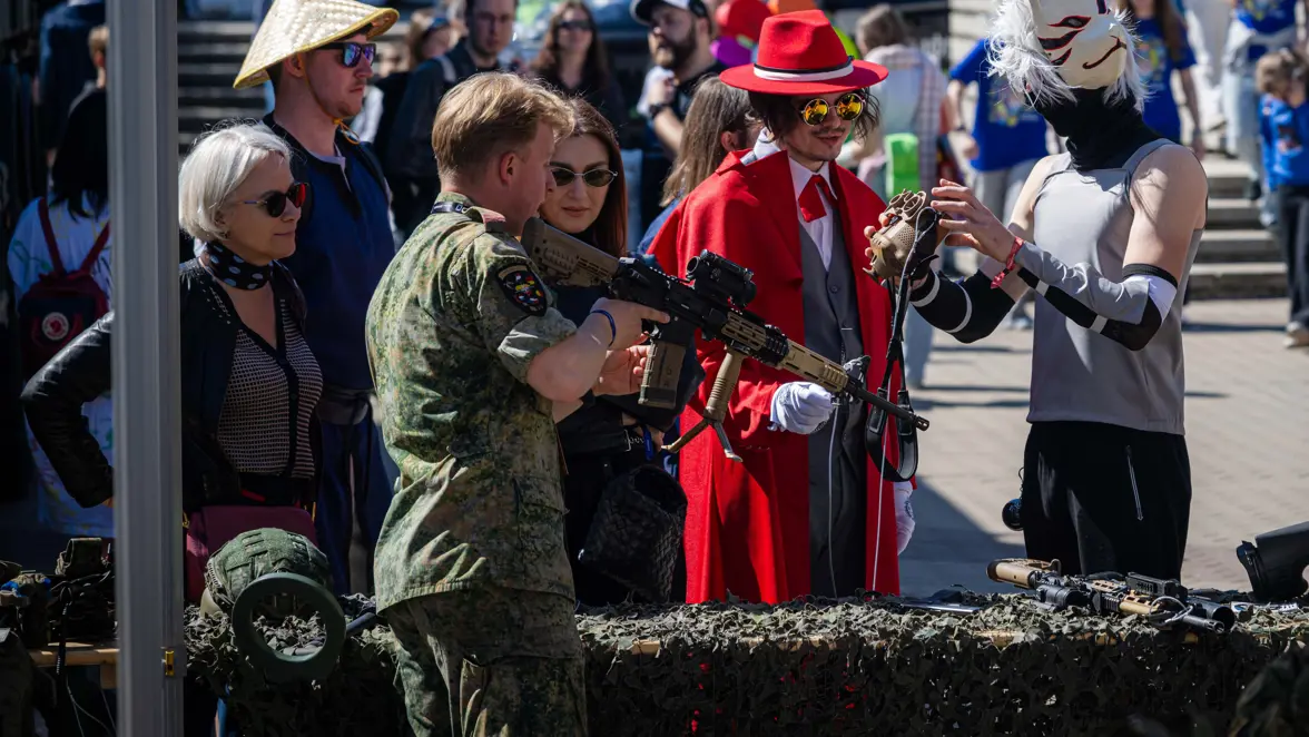 Een militair toont zijn geweer aan een burger. Een militair speelt een videogame.