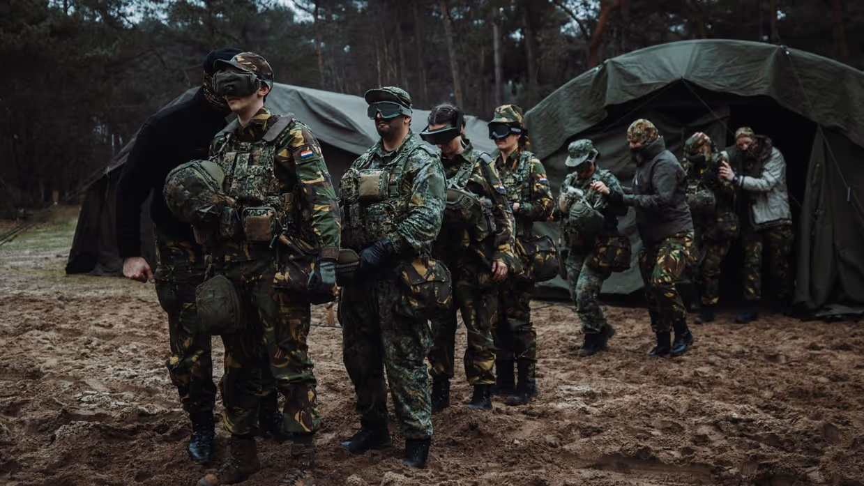 Soldaten geblinddoekt in bos voor tent.