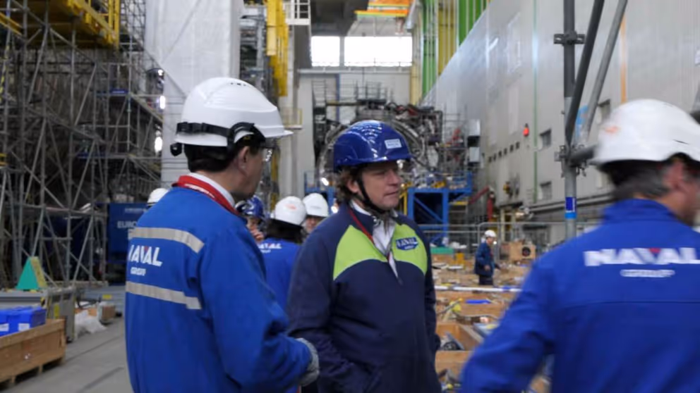 De staatssecretaris met 2 mannen van NAVAL Group. 