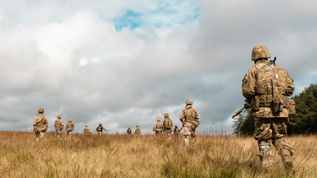 Militairen in het veld op de rug gezien.