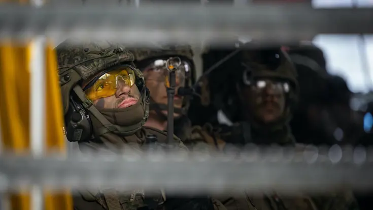 Militair met gele veiligheidsbril op tijdens oefening.