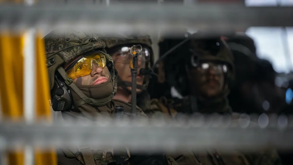 Militair met gele veiligheidsbril op tijdens oefening.