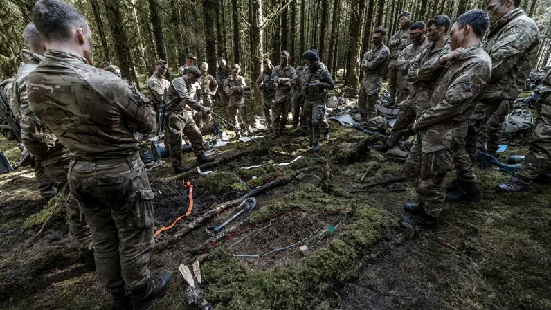 Een groep mariniers krijgt instructies in het veld.