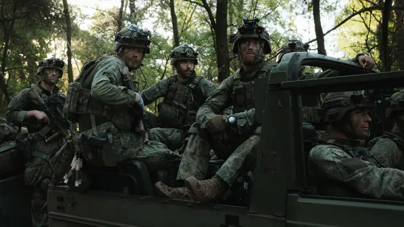 Militairen van 11 Luchtmobiele Brigade zitten met gevechtsuitrusting in een voertuig.