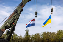 De Nederlandse en Oekraiense vlag wapperen in de lucht.