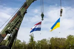 Een Nederlandse en een Oekraïense vlag hangen aan een kraan.