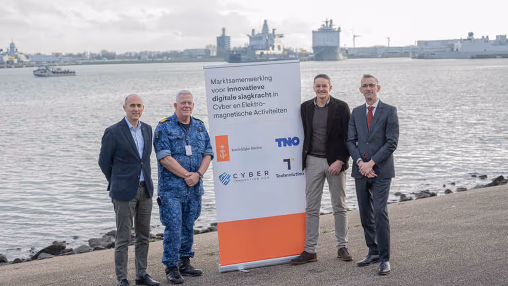 De 4 ondertekenaars staan op de kade van Den Helder met een banner tussen hen in.