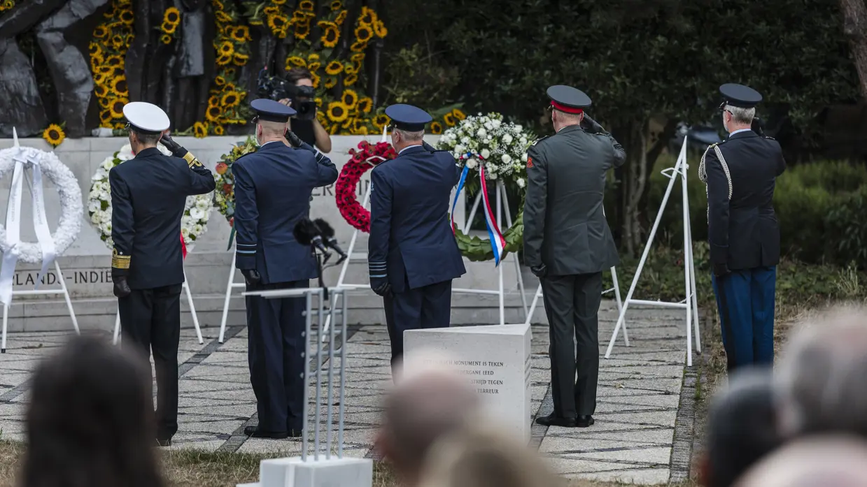 Militairen salueren bij een herdenking.
